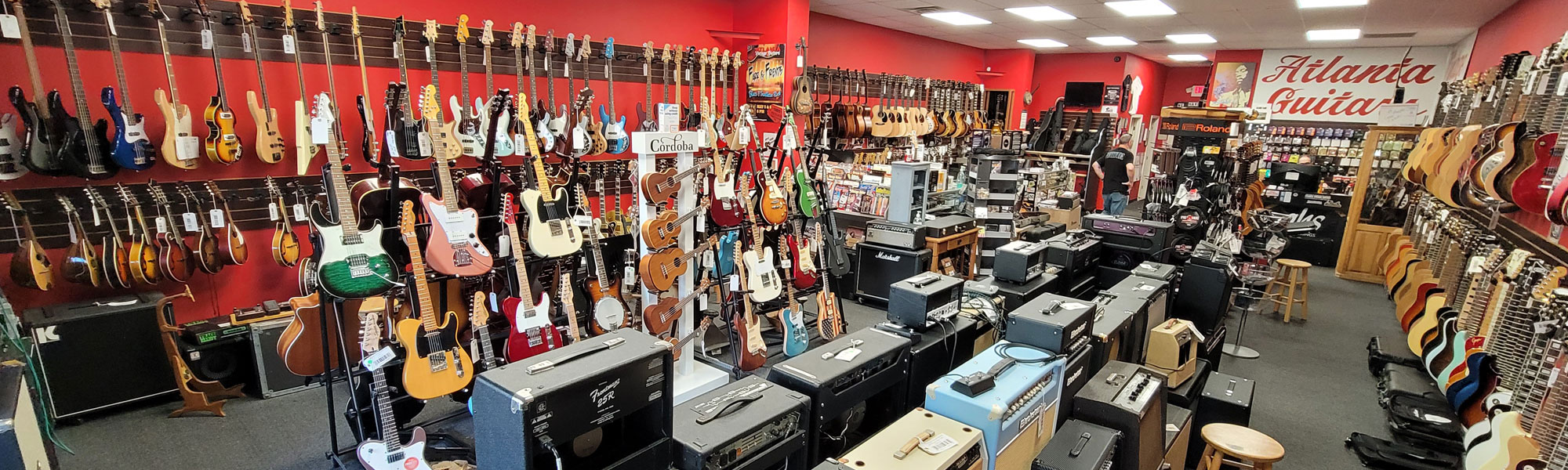 Inside Atlanta Vintage Guitars showing guitars on display and other merchandise on walls
